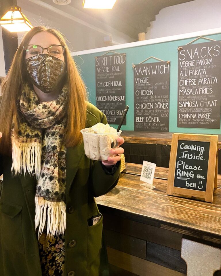 Masked customer holding food in Alif Cafe