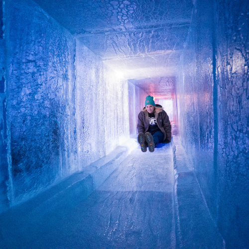 A woman going down a tunnel ice slide