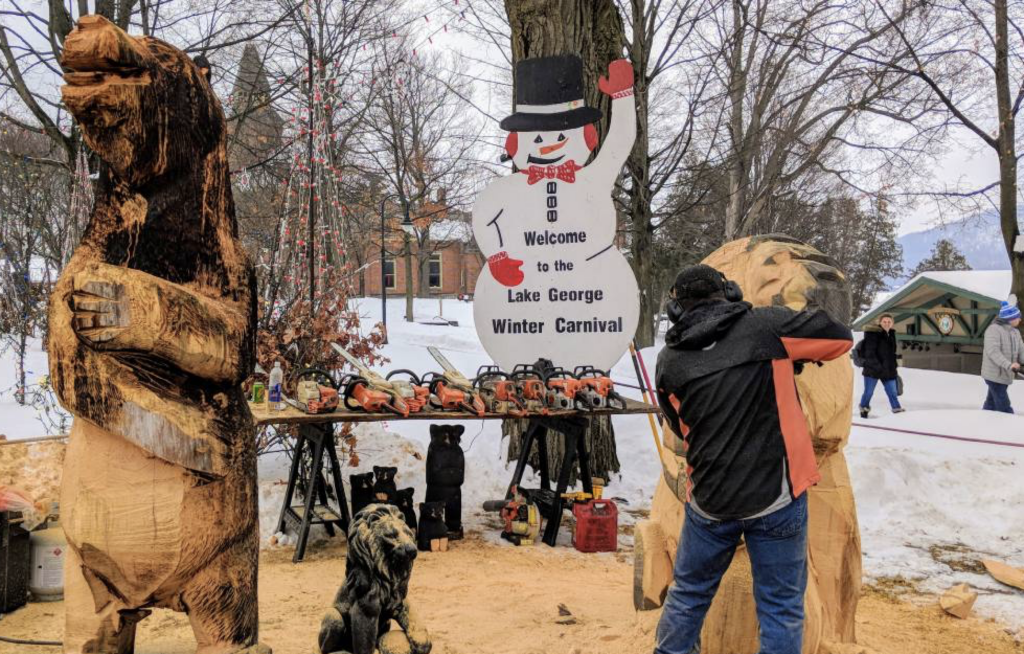 Man carving wooded sculptures with a chainsaw at the Lake George Winter Carnival