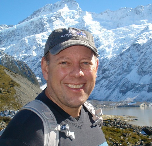 Jim Siplon smiling with snowy mountain in the background