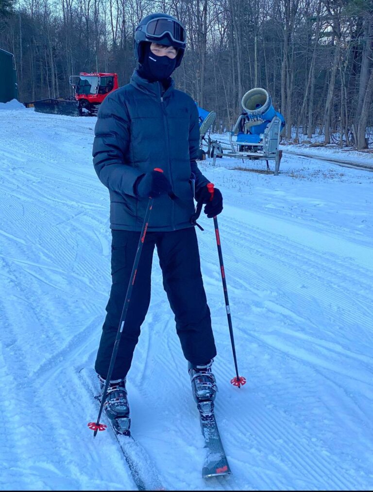 Kellen Driscoll with skis looking at camera