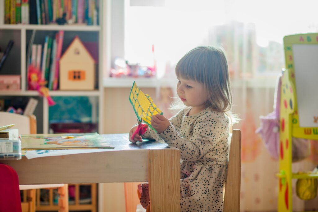 Little girl cutting paper